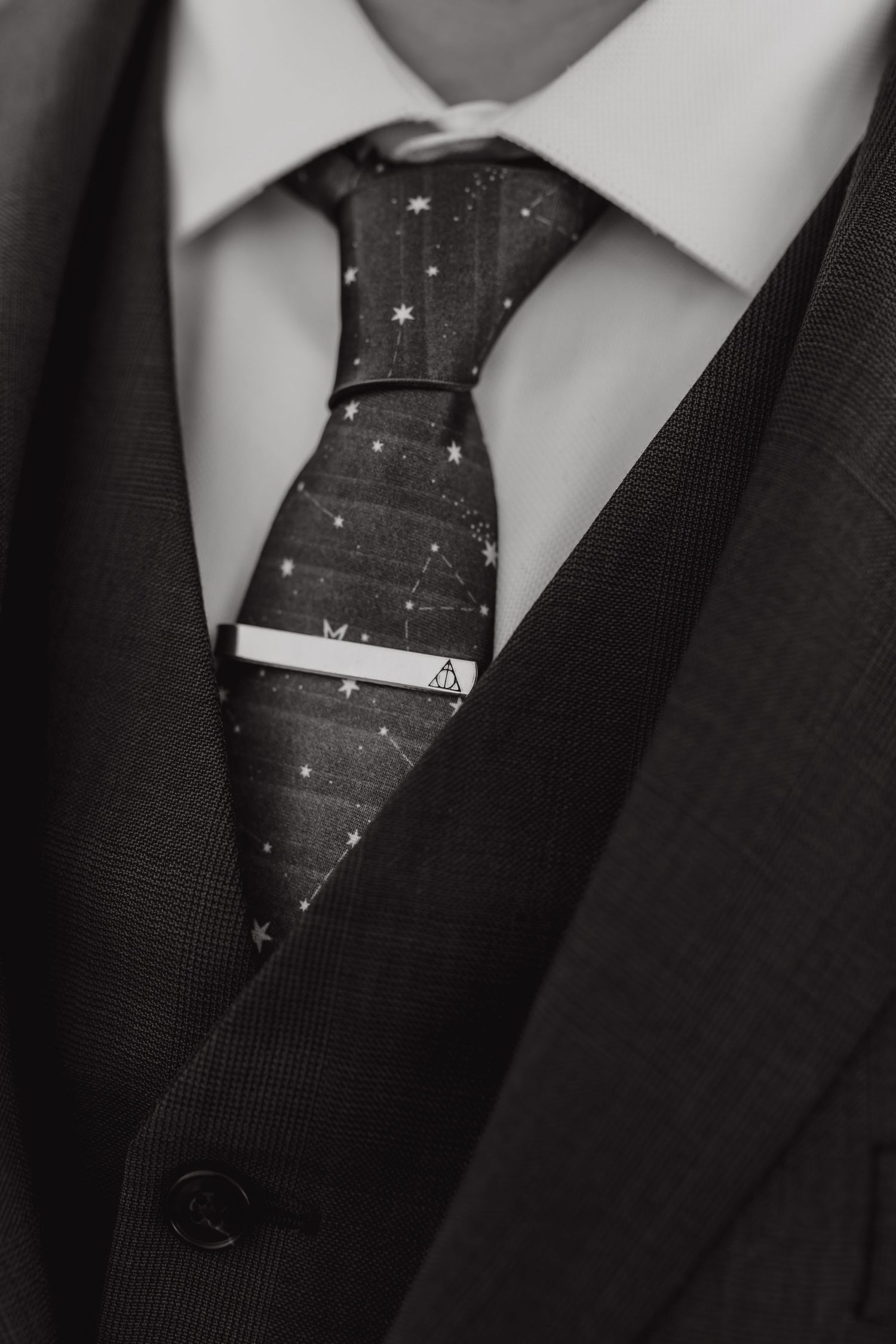 Close-up of polka dot tie and black suit collar detail.