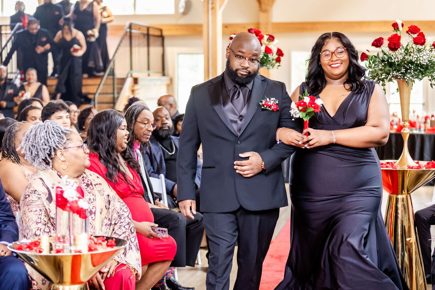 Wedding guests and attendants in formal attire watching ceremony proceedings.