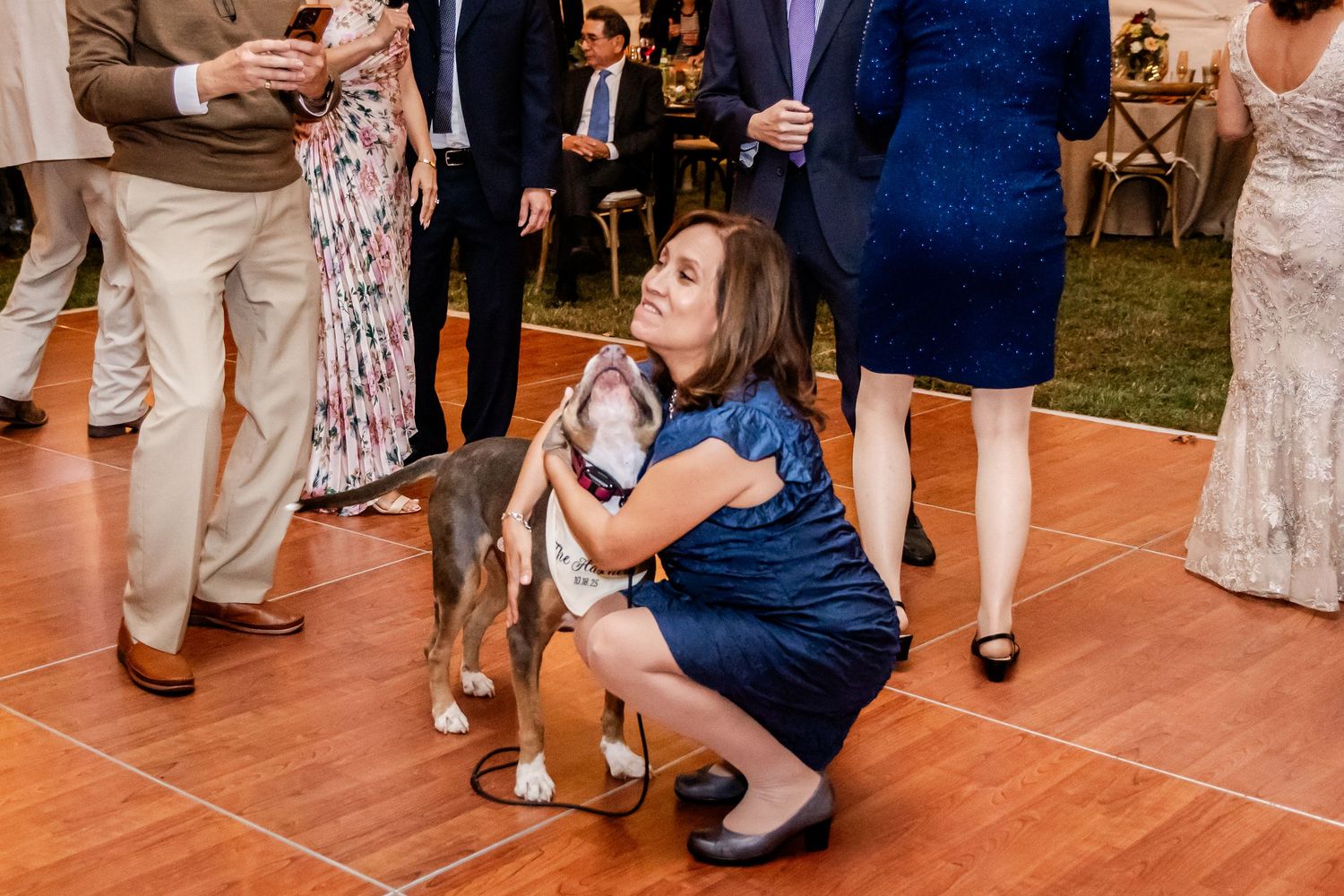 Guests dancing and celebrating on a wooden dance floor at an evening wedding reception.