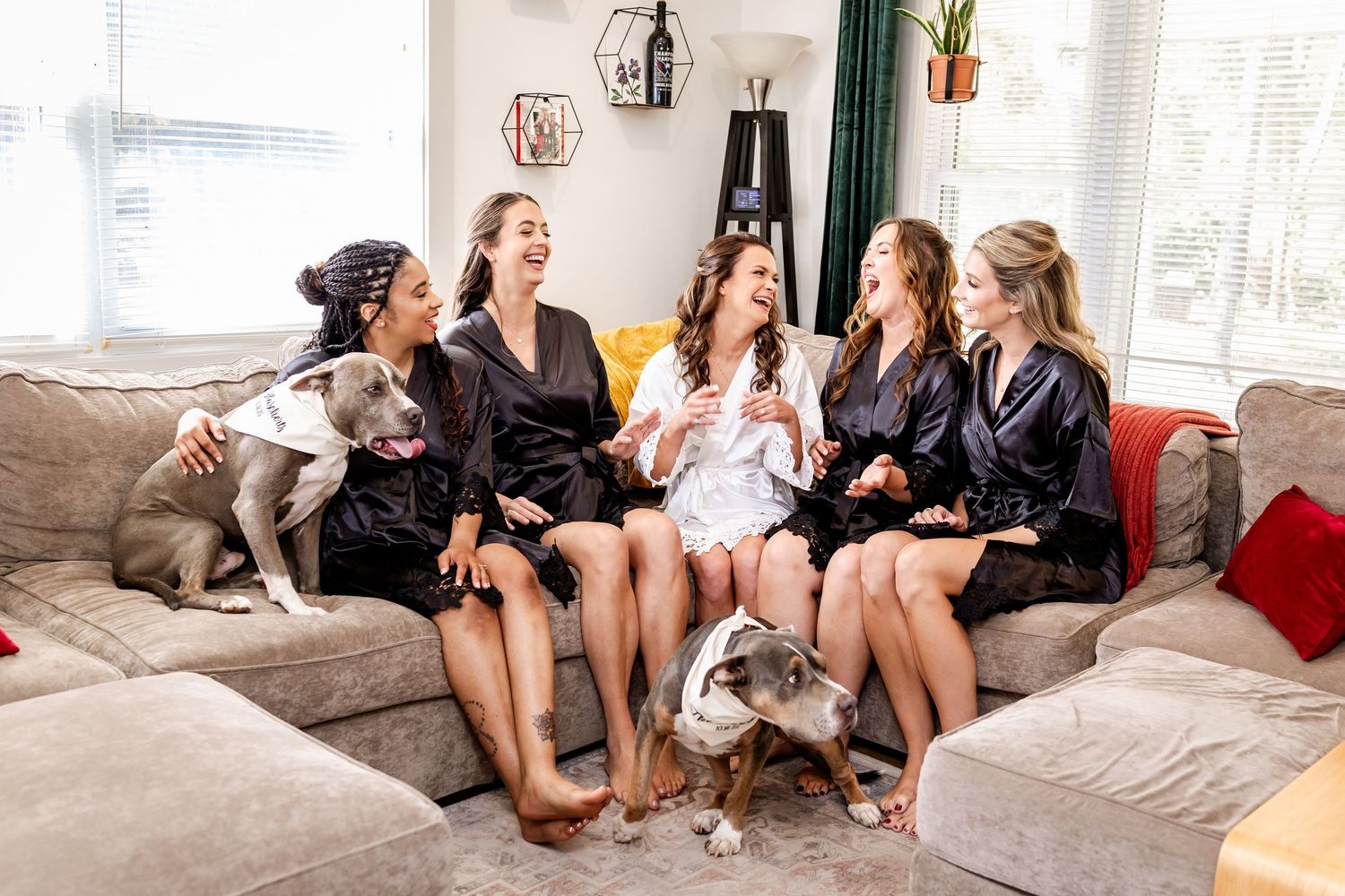 Wedding party relaxes on couches during pre-ceremony preparations.