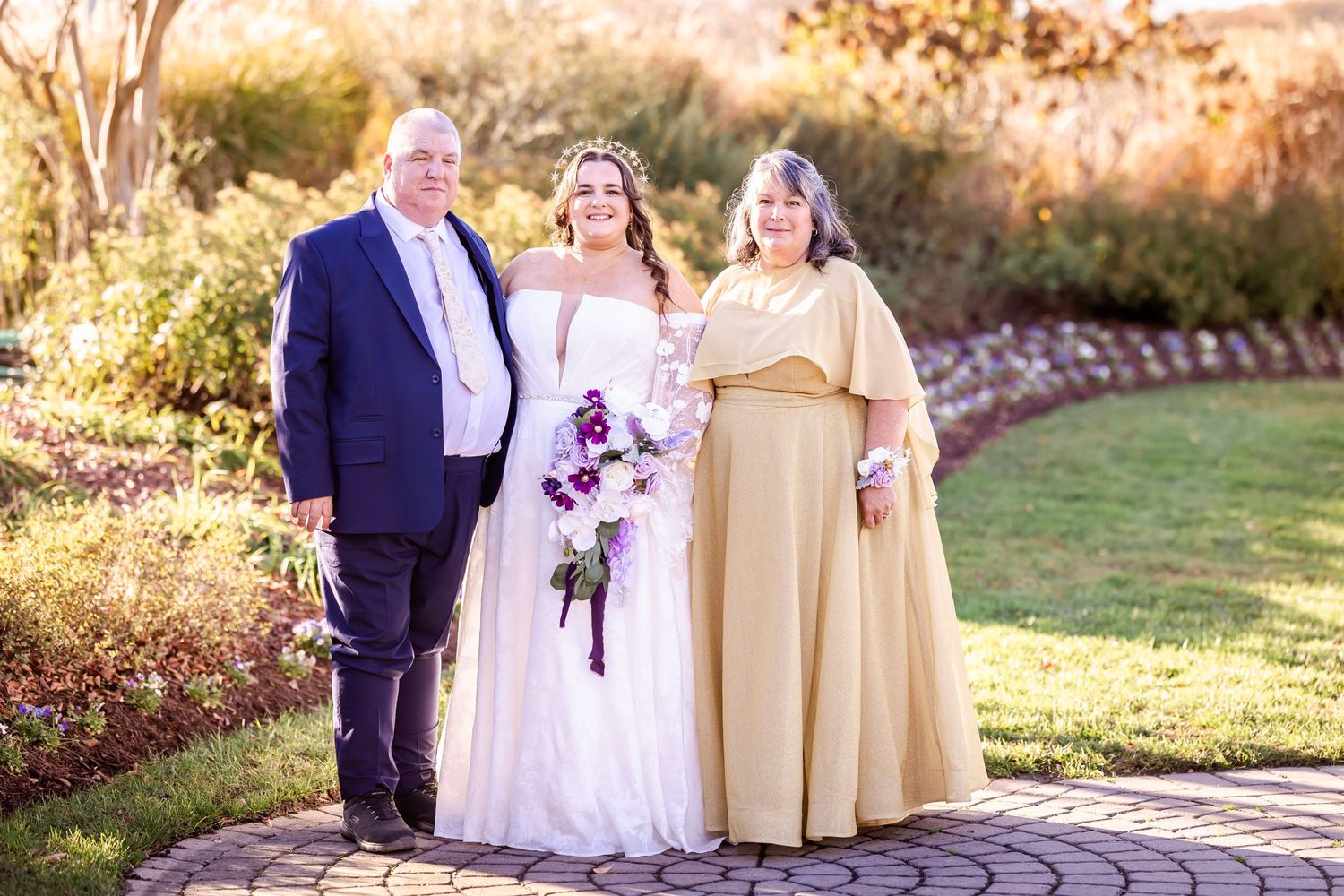 Family portrait at outdoor wedding with golden light setting.
