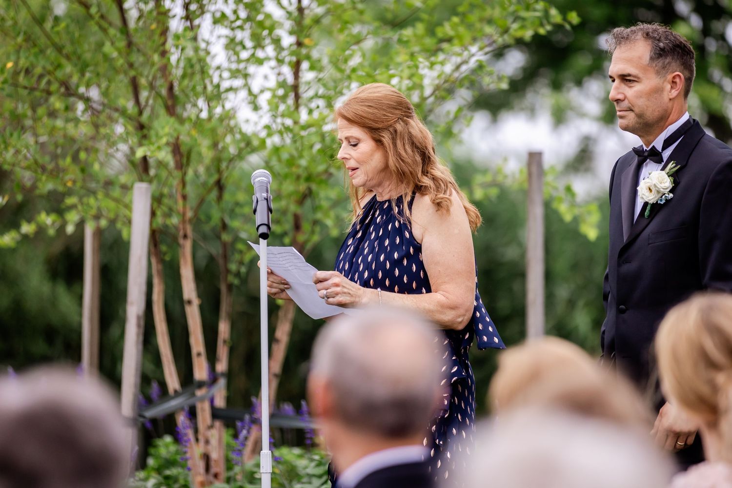Outdoor wedding ceremony with guests watching proceedings on a beautiful summer day.