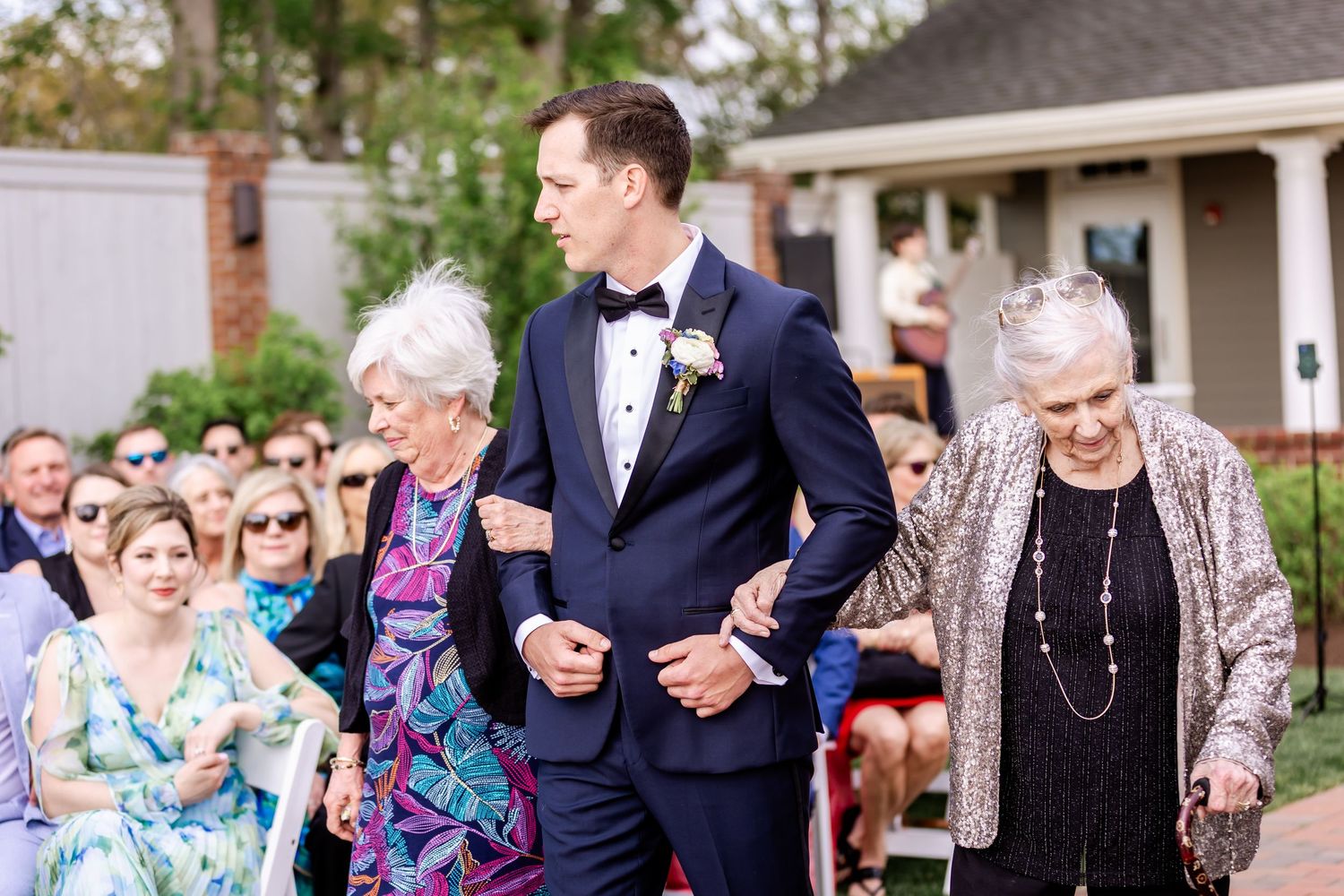 Wedding guests mingling and laughing during an outdoor garden reception.