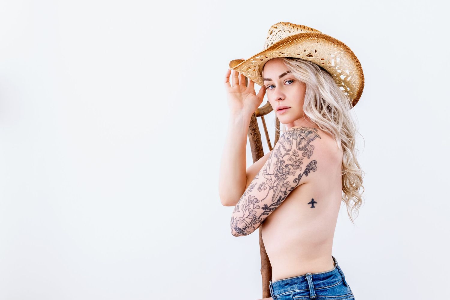 A person in a cowboy hat and denim poses in a series of casual portraits against a white background.