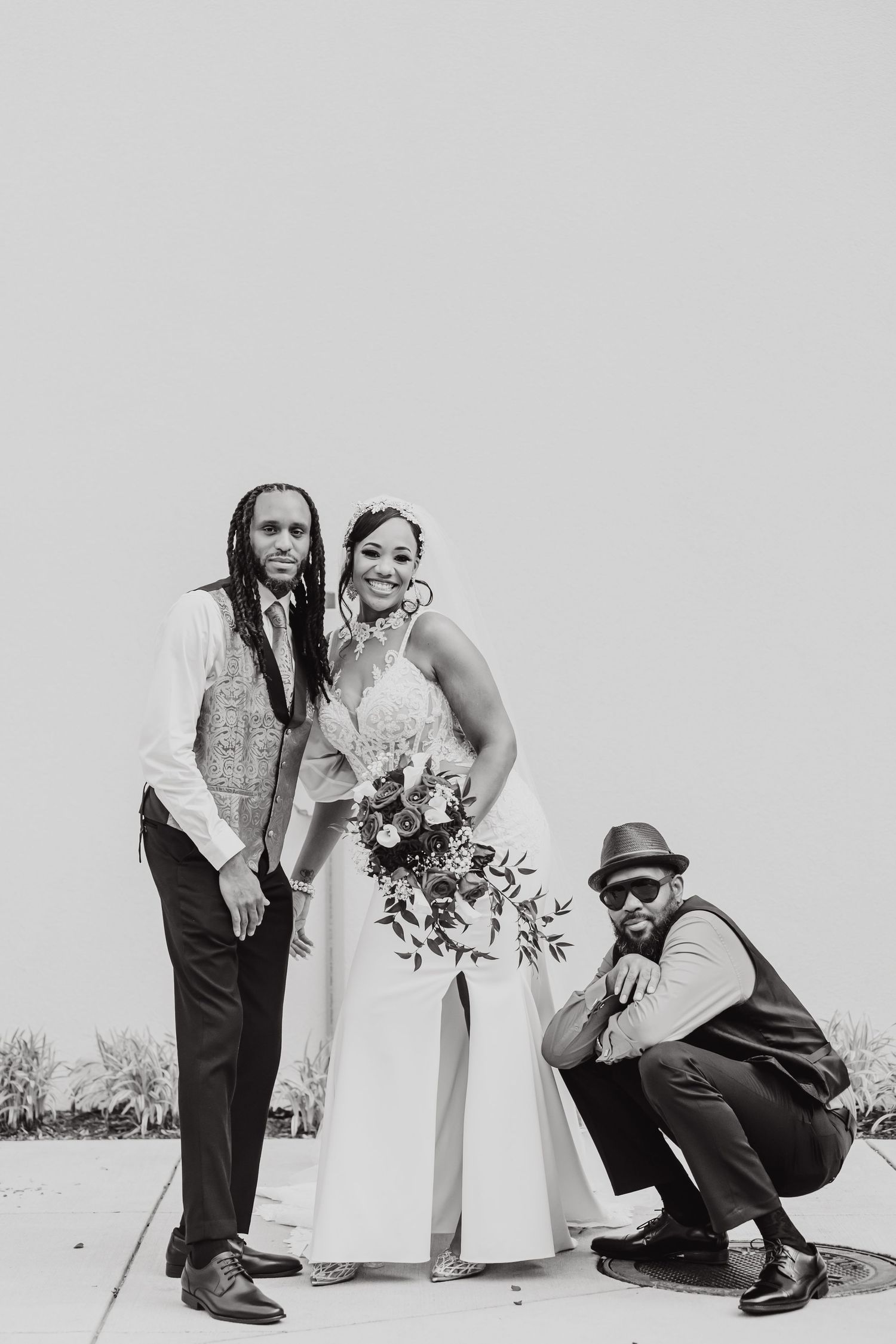 Black and white artistic wedding portrait against minimalist background.