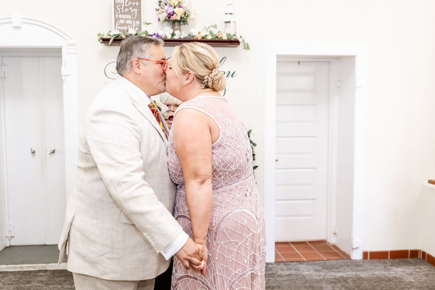 A tender moment captured during a wedding ceremony in a white chapel setting.