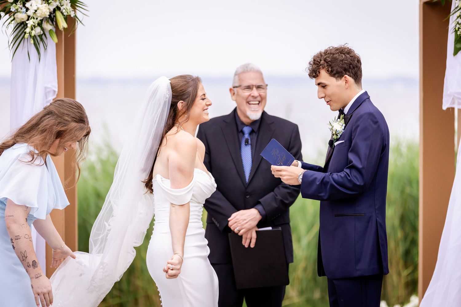 Wedding party members share joyful moments during an outdoor celebration.