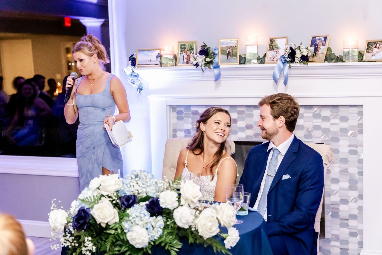 Wedding reception guests dance and celebrate on an elegant dance floor with blue and warm lighting.