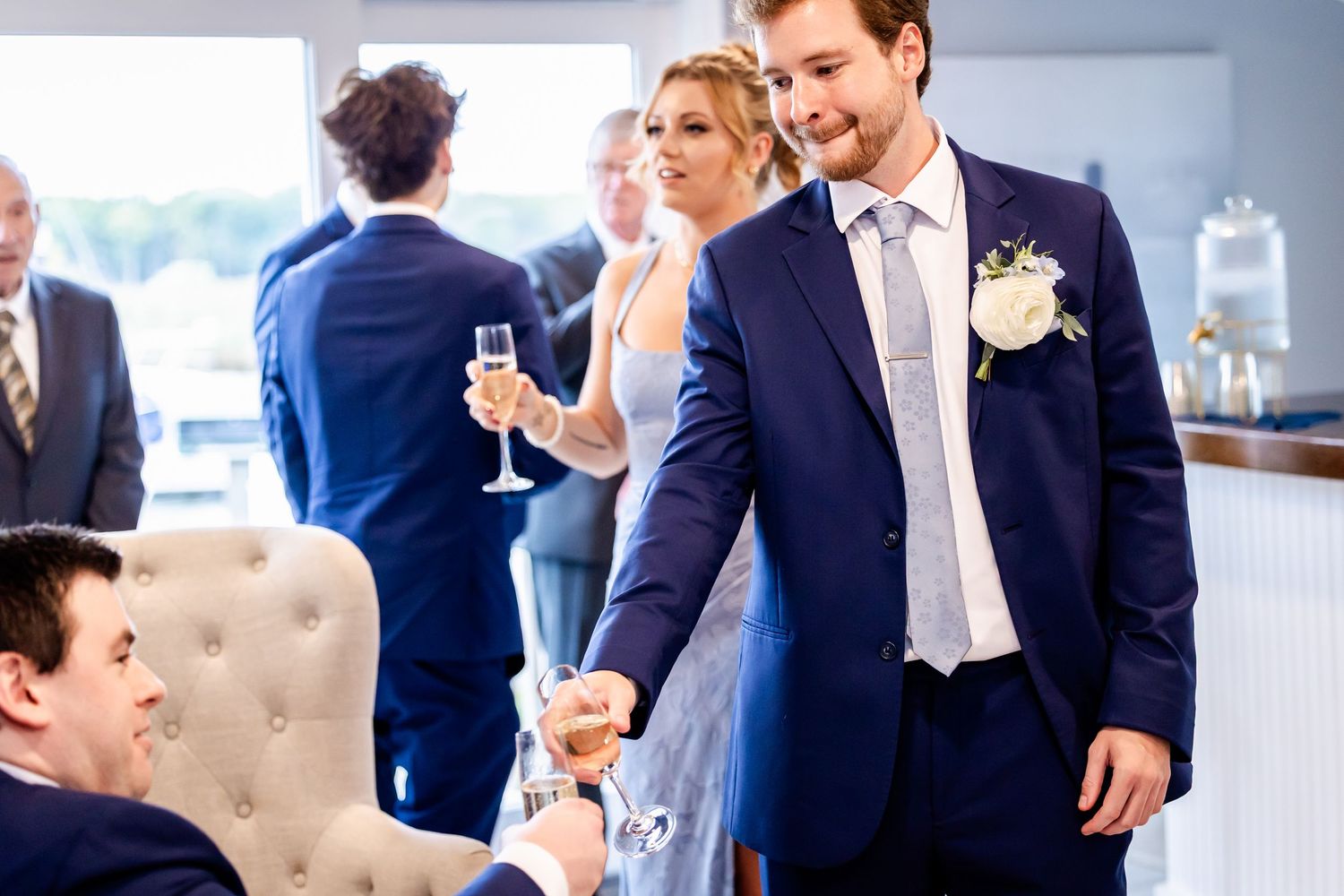 An elegant indoor wedding reception space with blue and white decor and natural lighting.