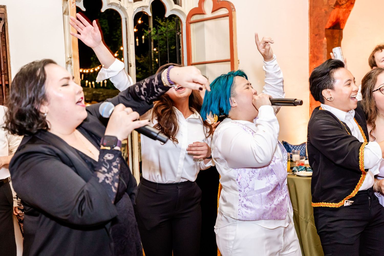 Energetic guests singing and dancing together at a festive indoor party.