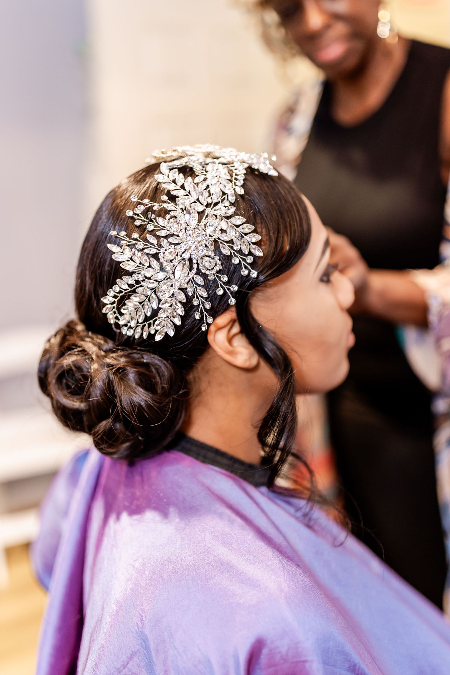 Close-up of an elegant bridal hair accessory featuring intricate crystal floral designs in silver against dark hair.