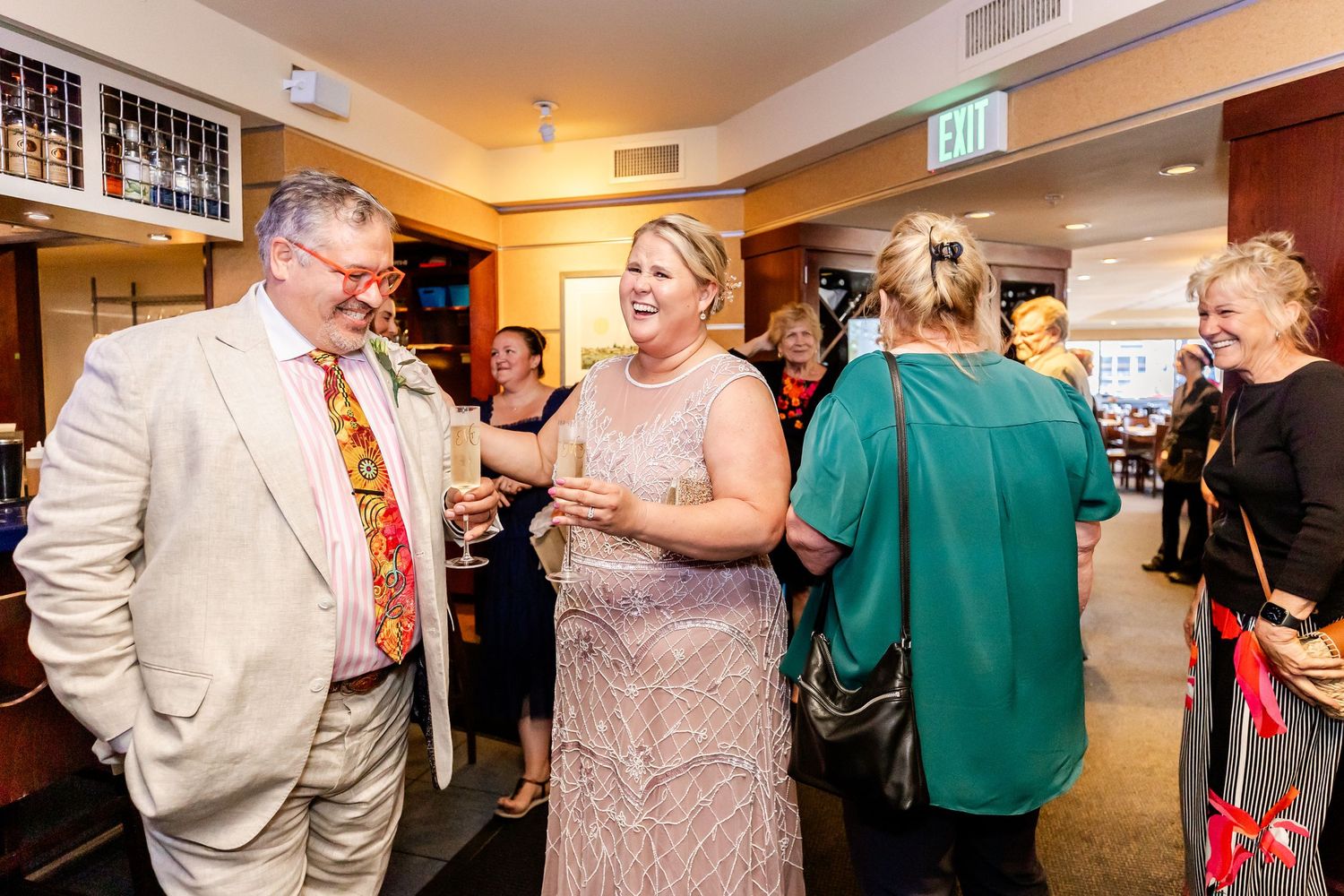 Social gathering with guests mingling and chatting in bar setting.