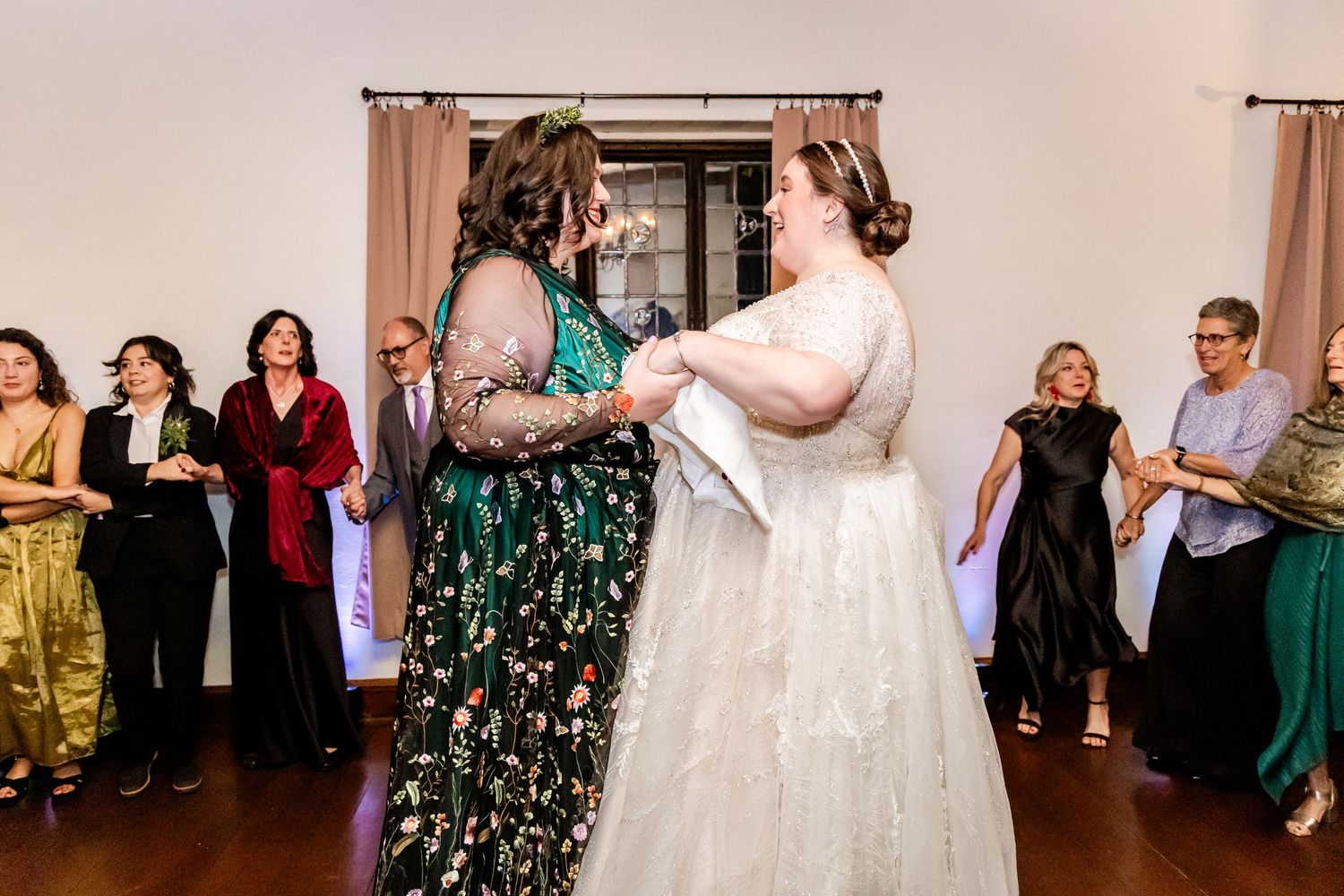 Wedding guests enjoying a dance together during an indoor reception celebration.