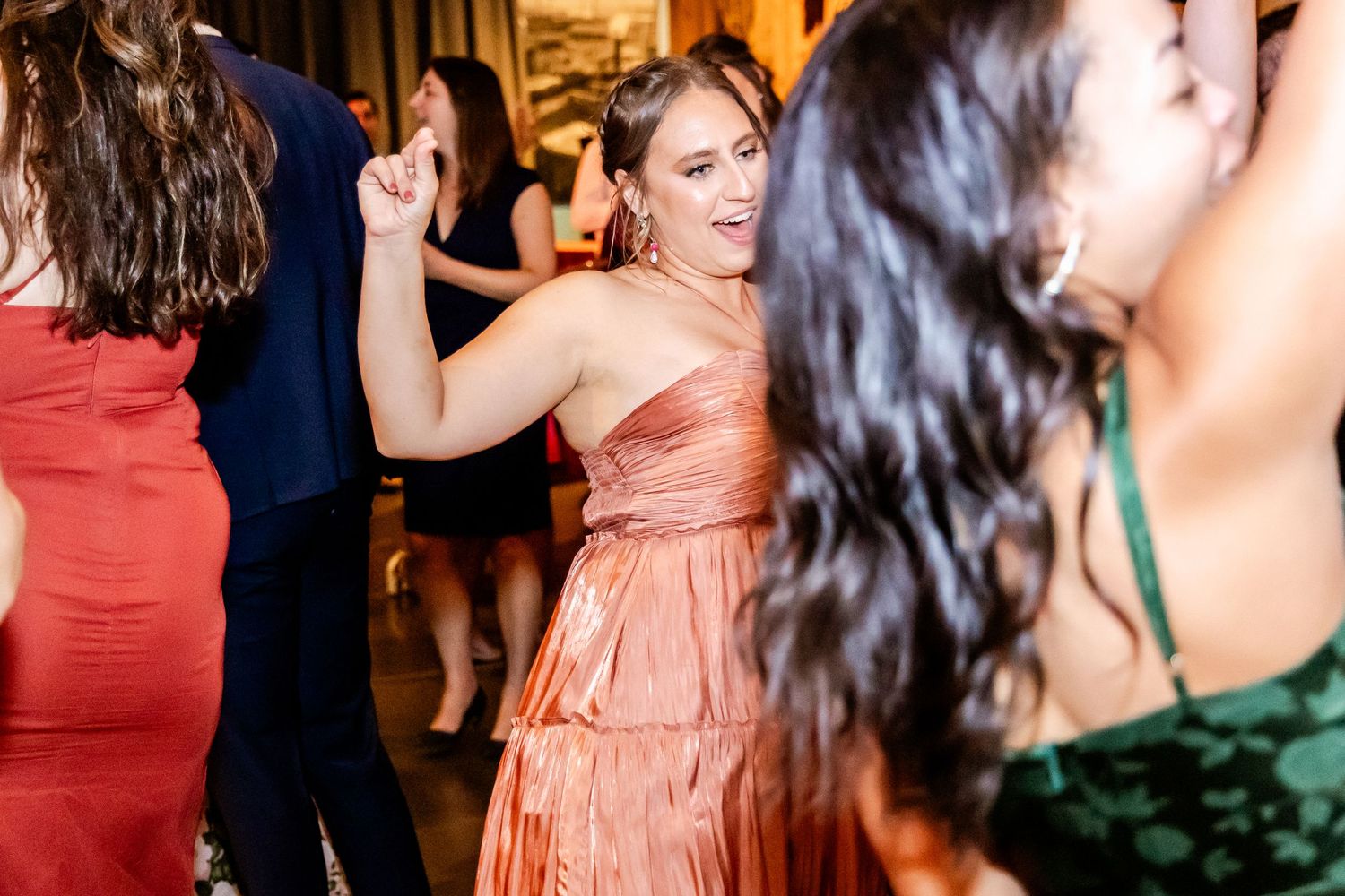 Wedding reception guests dancing in formal attire at evening celebration.