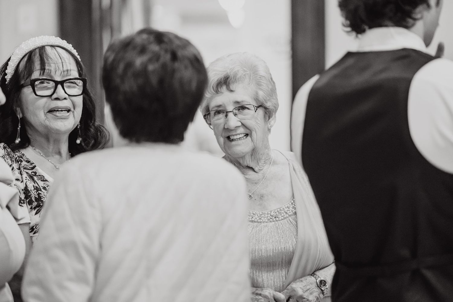 Wedding guests share joyful conversation during reception celebration.