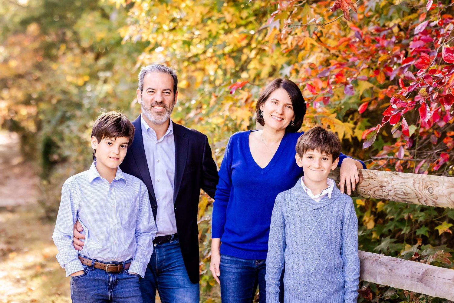 Family group photos against vibrant fall trees showing natural interactions and smiles.