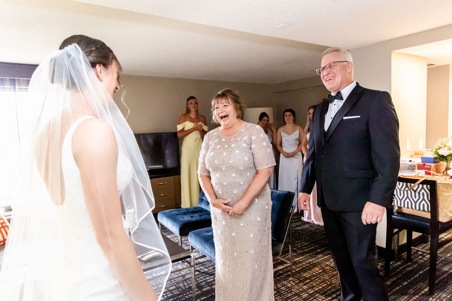 A panoramic view of a wedding celebration in a hotel room with guests gathered in formal attire.
