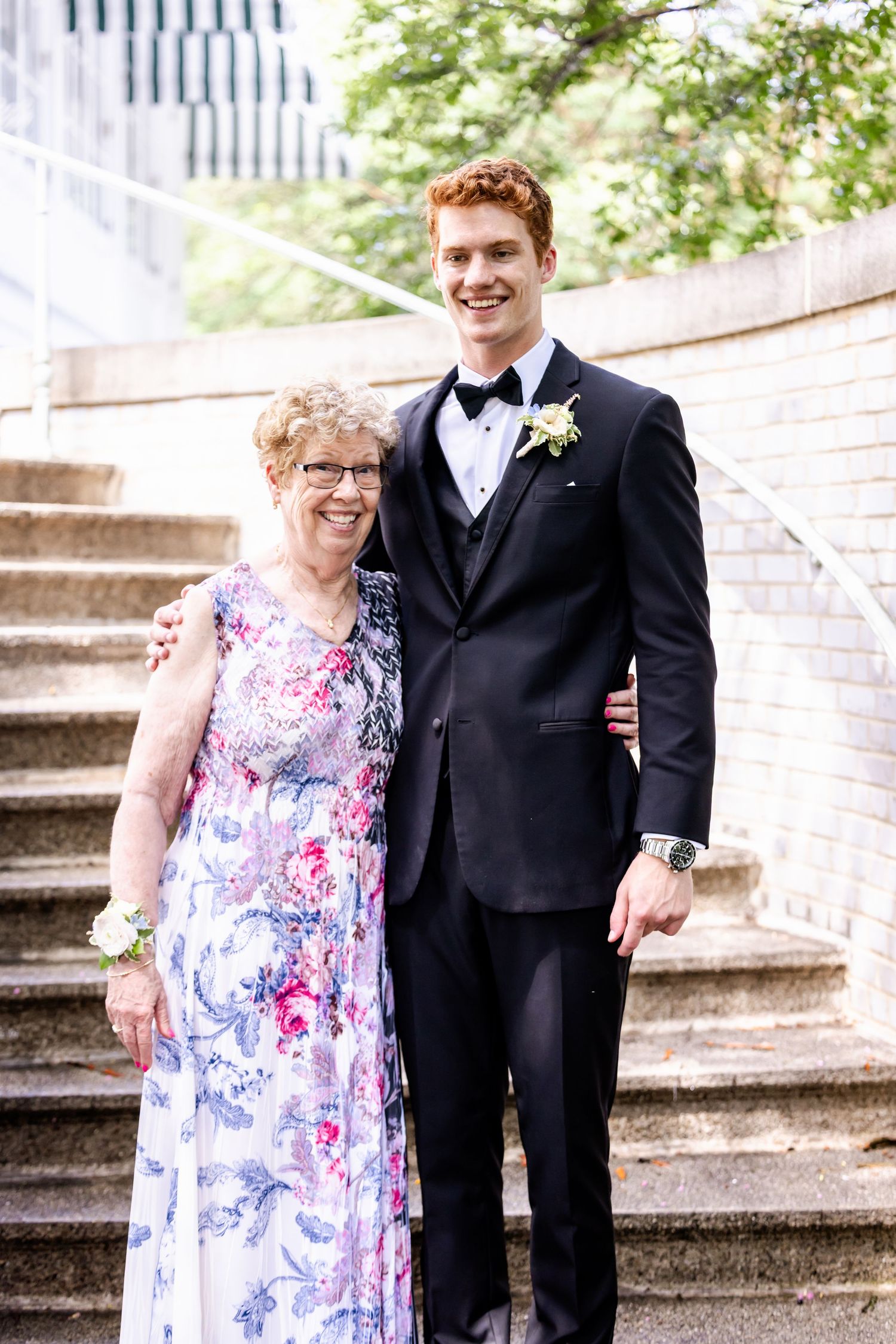 Formal portrait on stone steps showing two people in elegant attire.