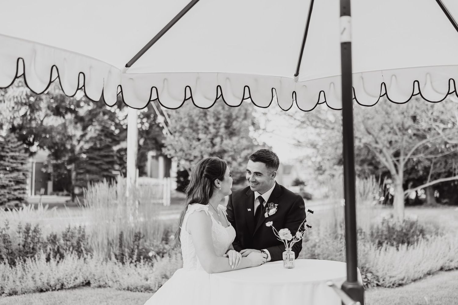 A series of black and white wedding photographs arranged in a horizontal filmstrip showing outdoor ceremony moments.