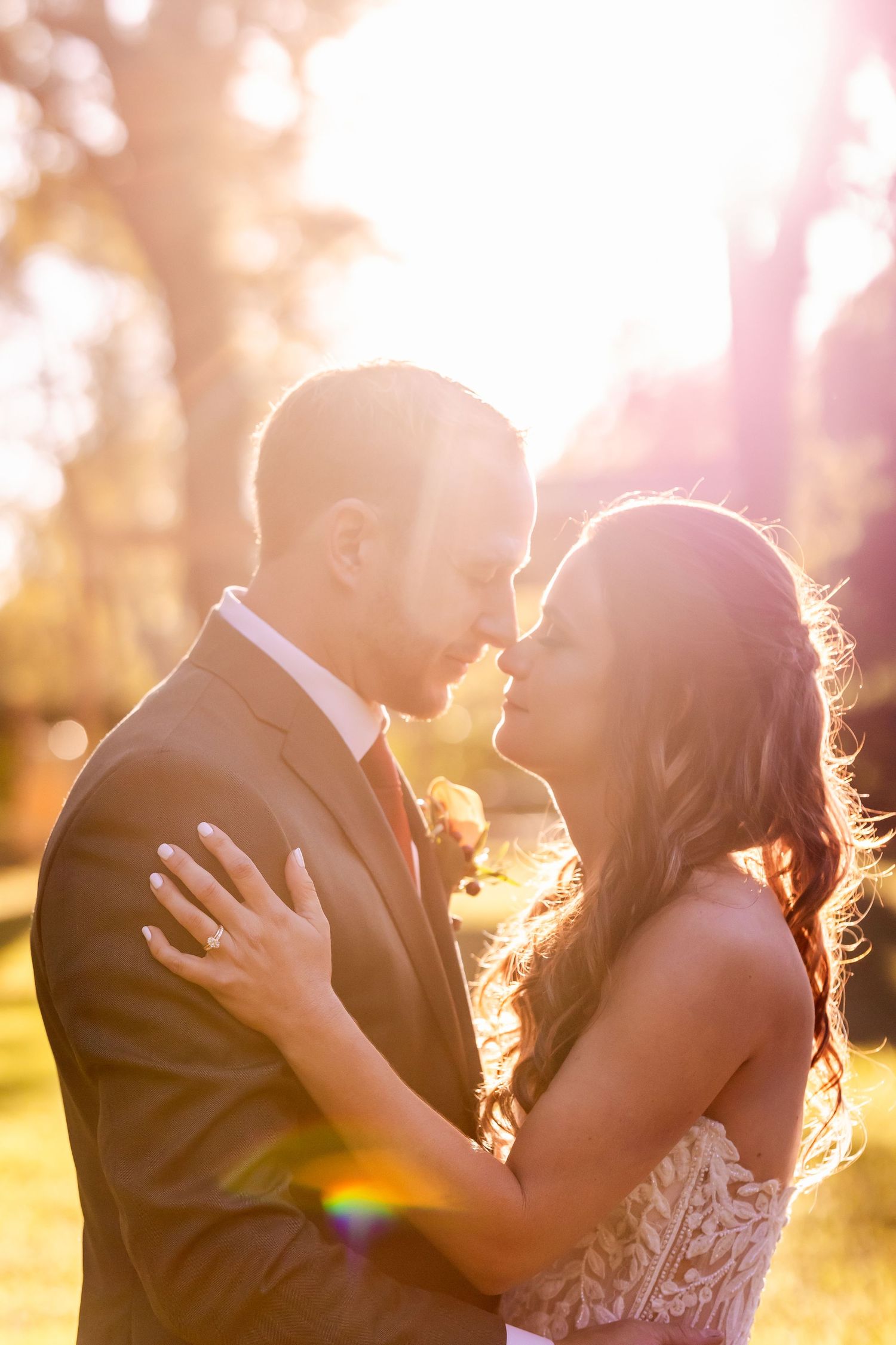 A romantic sunset wedding portrait in golden light with soft bokeh background.