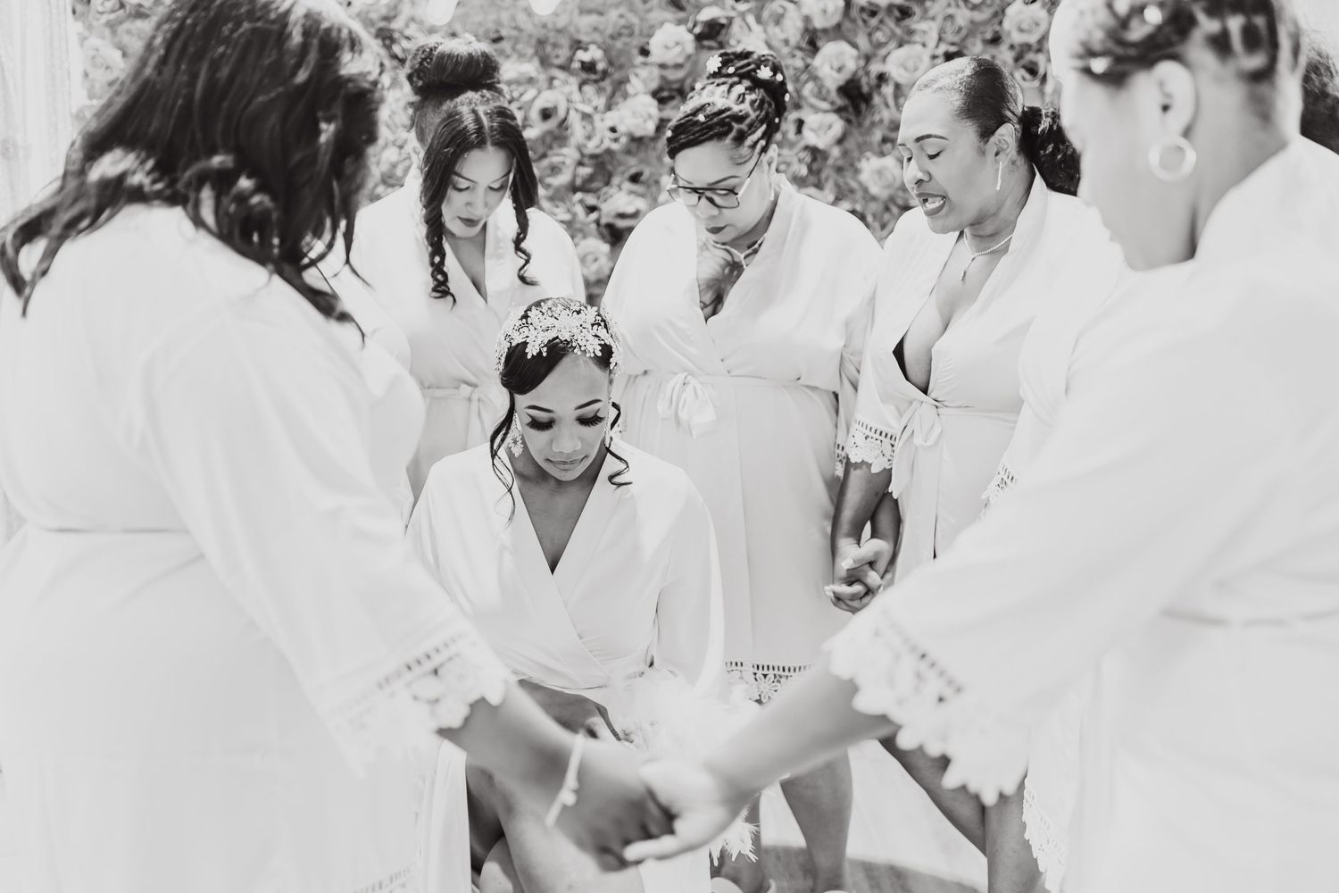 Black and white candid shot of wedding party preparing in white robes.