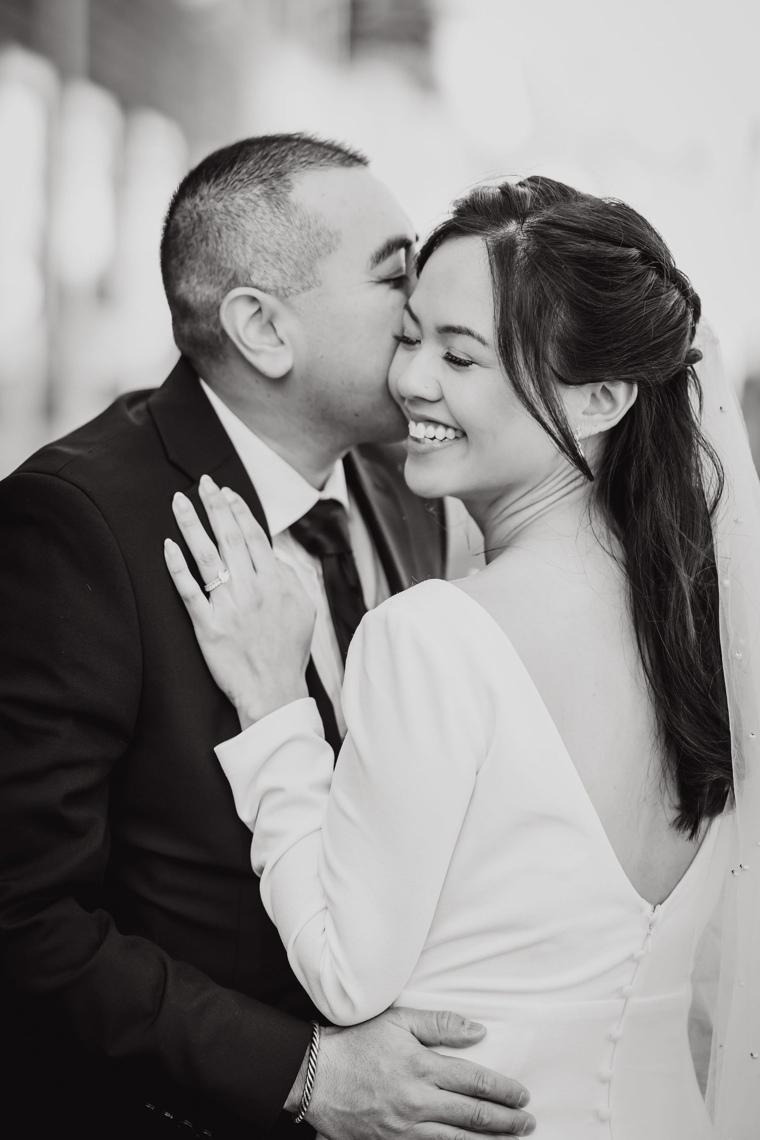 Intimate black and white portrait of newlyweds sharing tender moment.