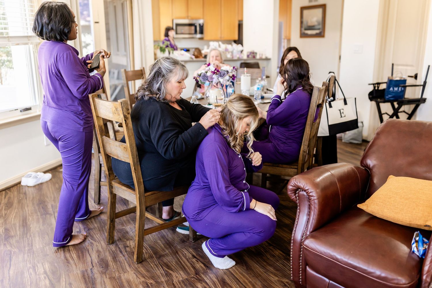 Group wearing purple uniforms gathered in a living room setting.