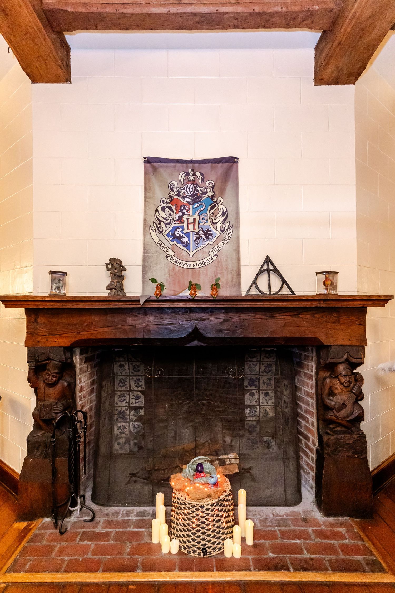 A Harry Potter themed fireplace mantel decorated with Hogwarts crest banner and magical decorations.