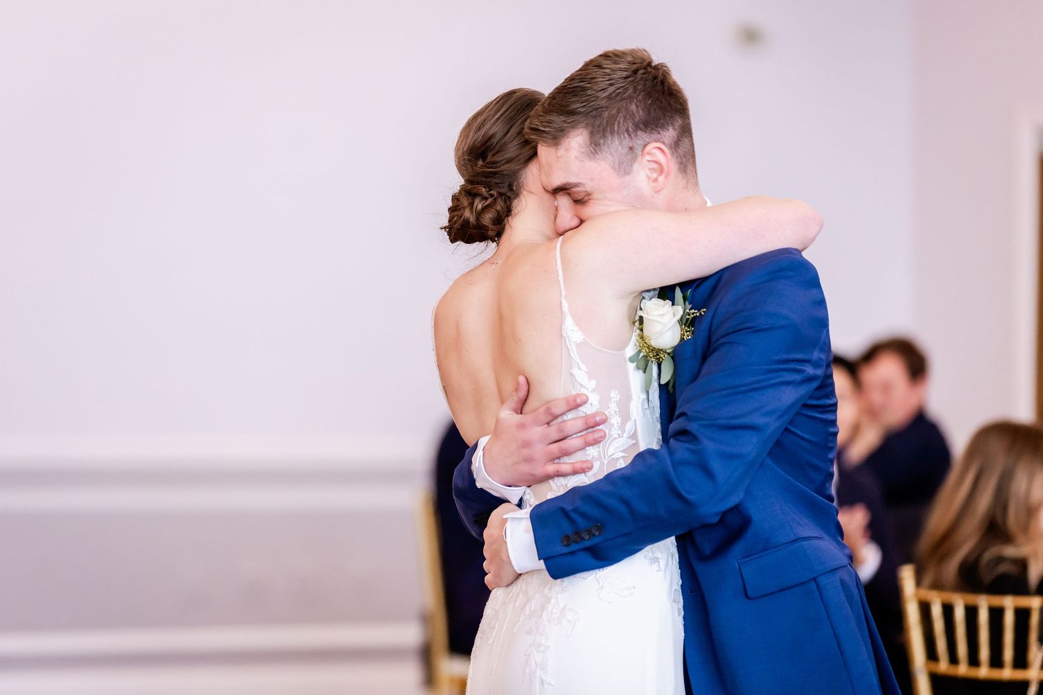 Wedding guests dance and celebrate together at an indoor reception venue with string lights.