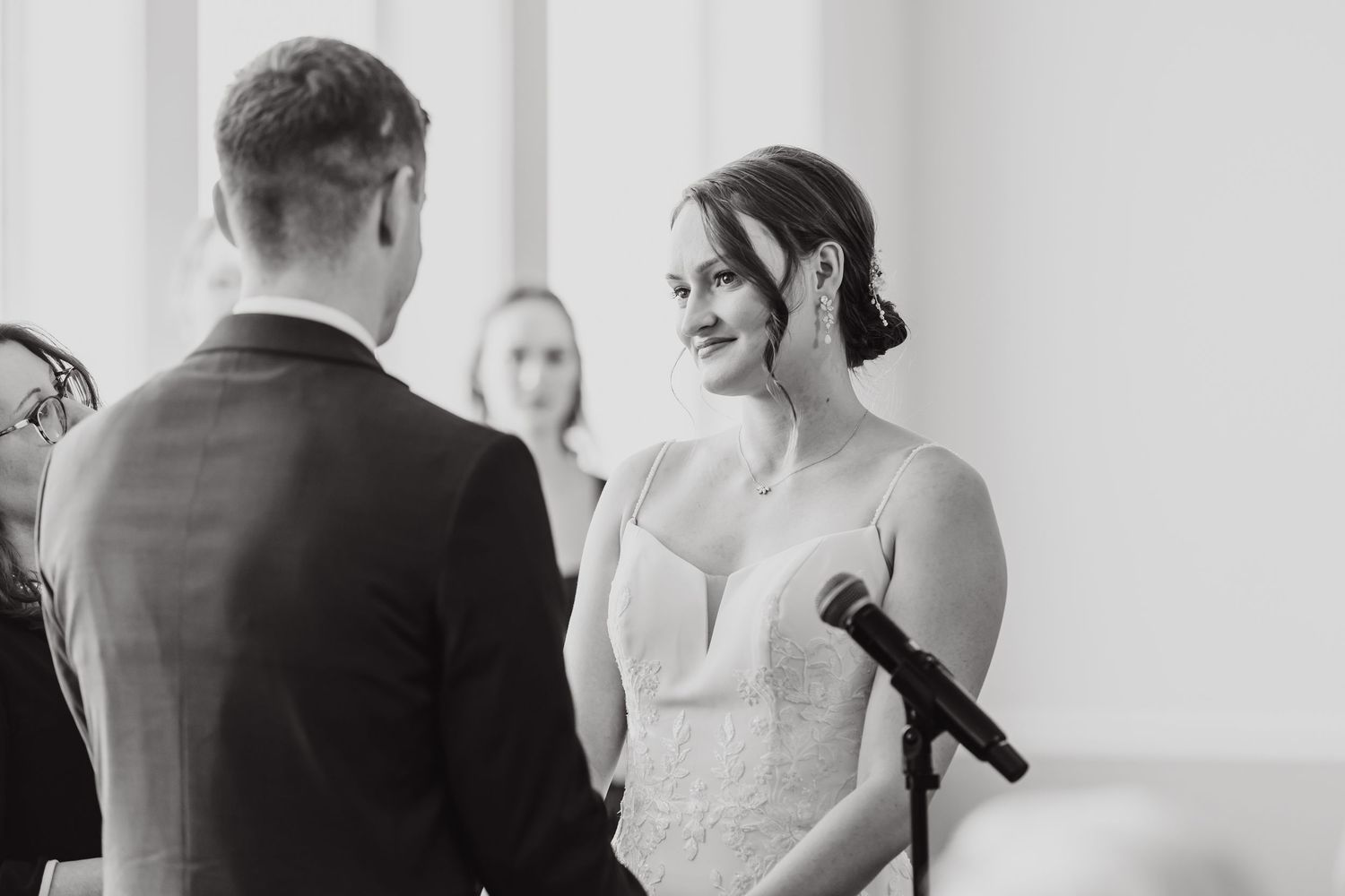 Black and white candid shots capturing intimate moments during an indoor wedding ceremony.