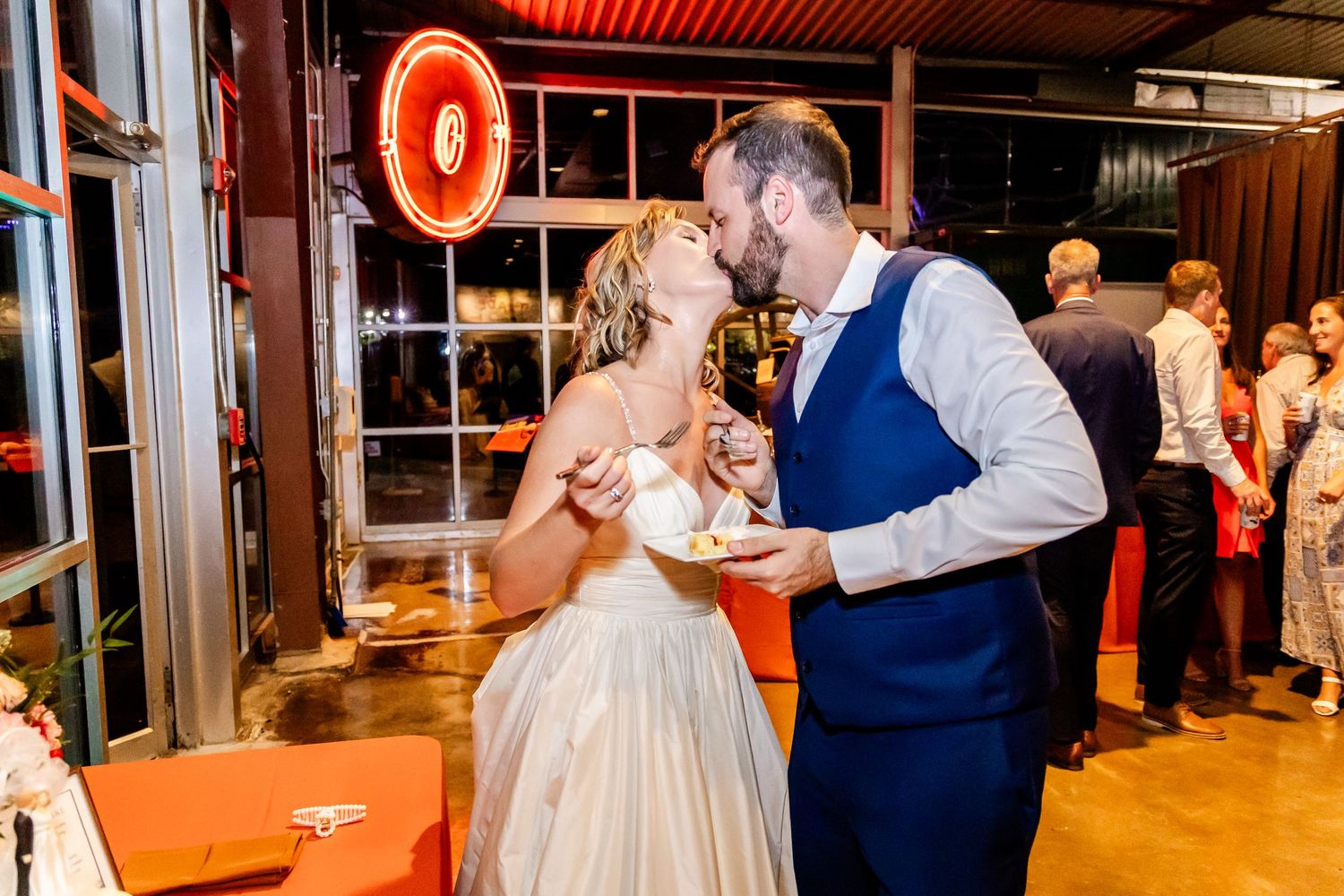 Newlyweds share a sweet moment while eating cake at their wedding reception.