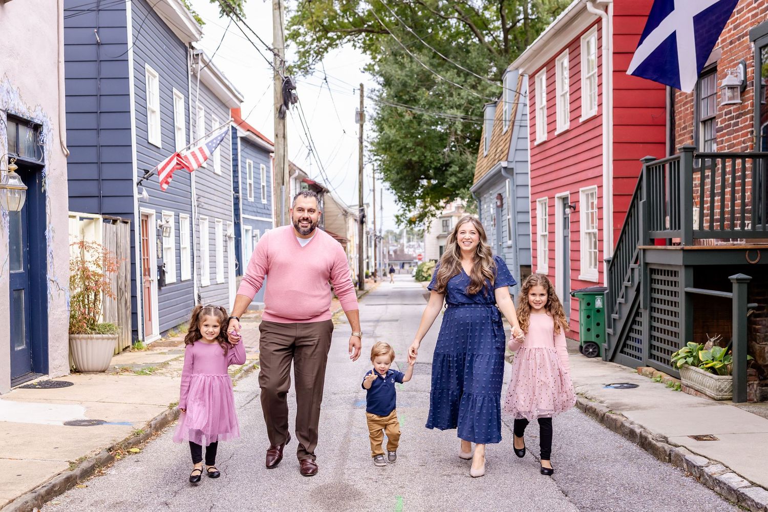 A group walks down a colorful street lined with historic houses in Lunenburg, Nova Scotia.