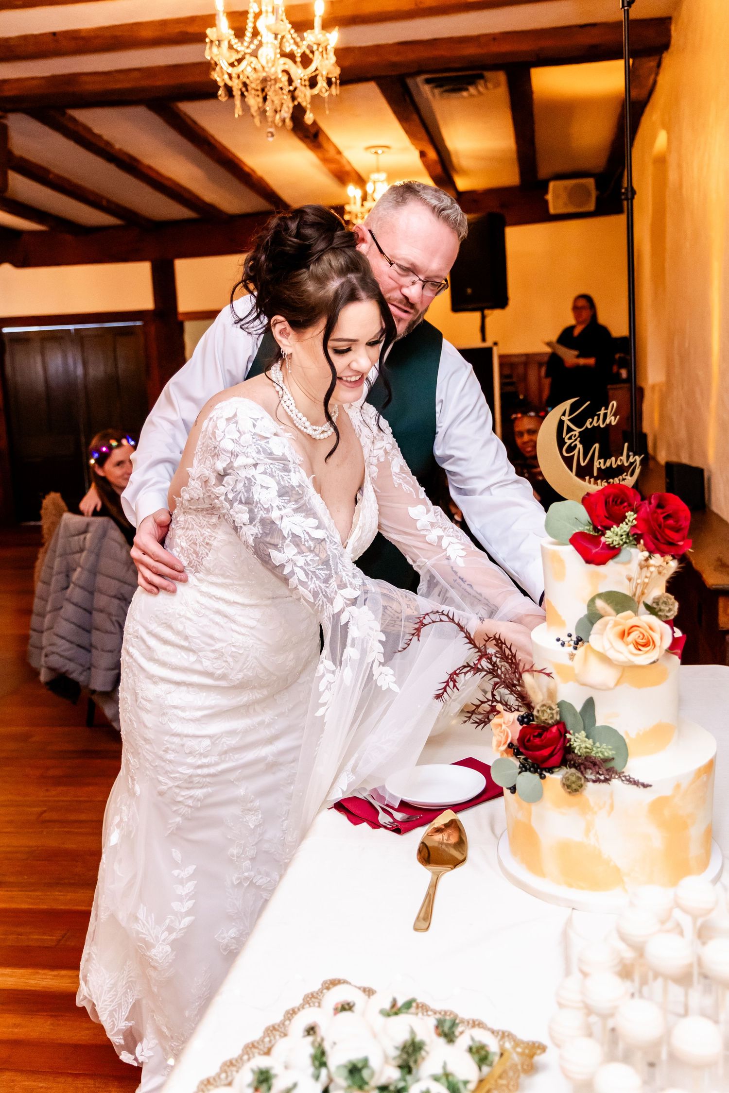 Newlyweds cutting their elegant white wedding cake together at the reception.