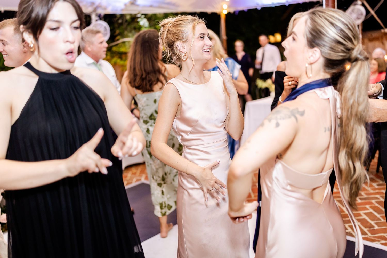 Guests in formal attire dancing and celebrating at an elegant wedding reception.