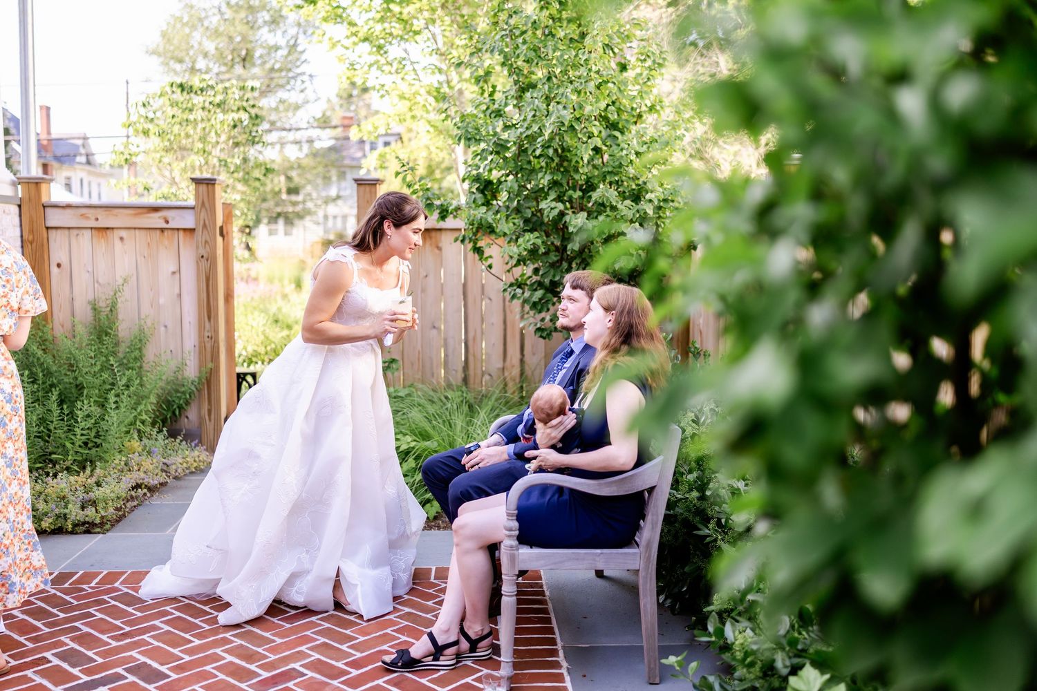 A wedding celebration moment in a garden setting with greenery and brick patio.