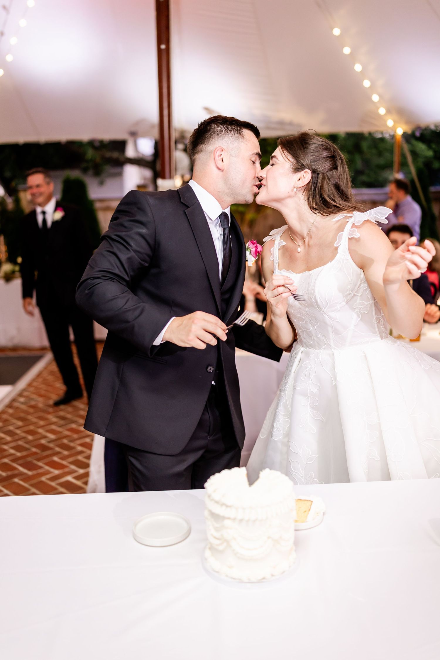 Couple shares romantic moment while cutting their wedding cake at reception.