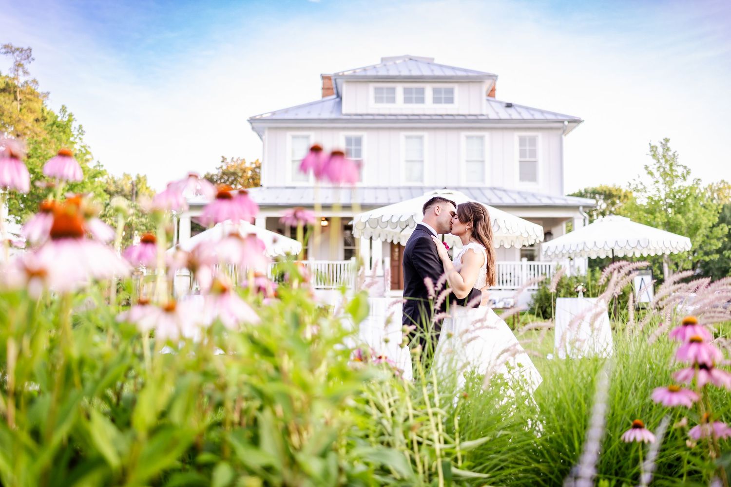 Beautiful white wedding venue with pink flowers blooming in the garden.
