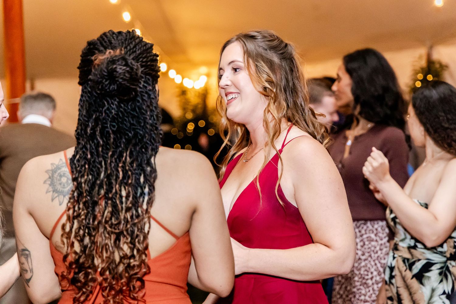 Wedding guests dancing and celebrating at indoor reception.