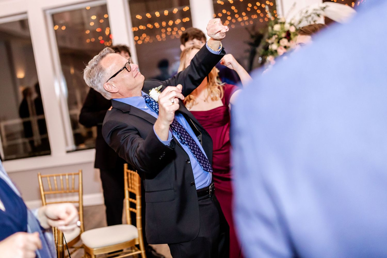 Wedding reception venue with string lights and guests dancing.