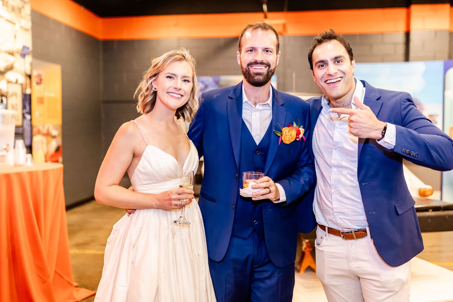 Wedding celebration at an indoor reception with guests in formal attire sharing drinks and smiles.