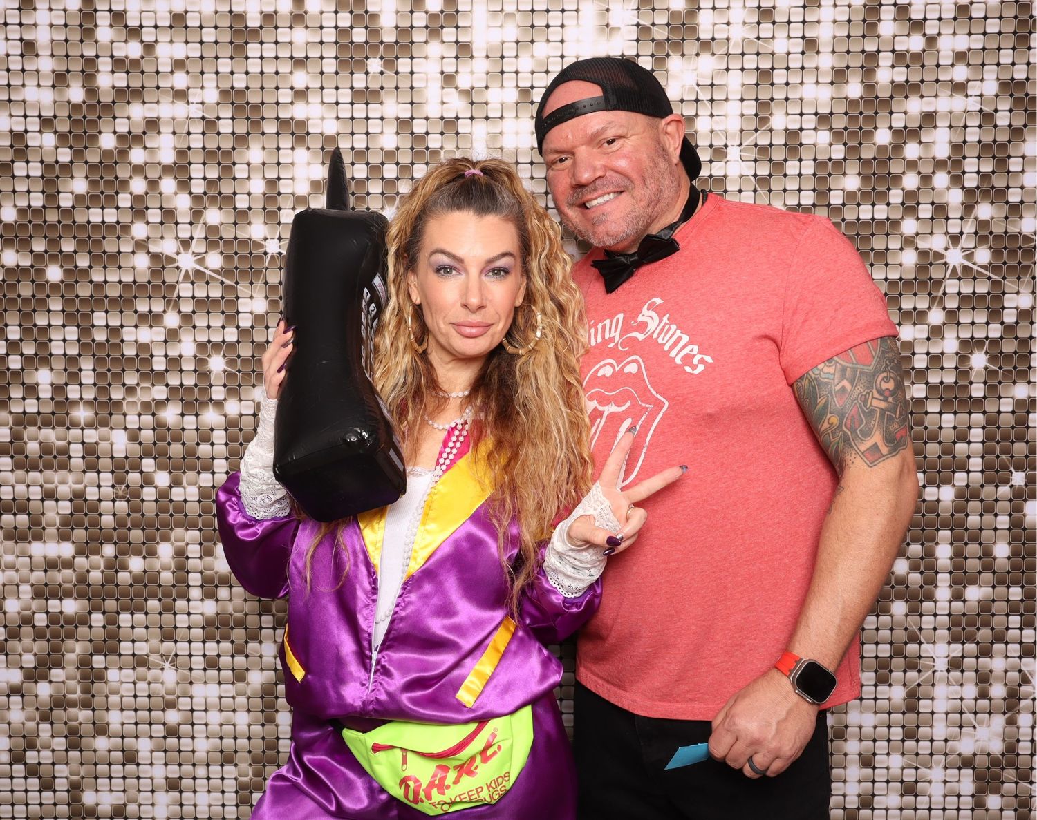 Party photo booth scene with sparkly silver sequin backdrop and casual attire.