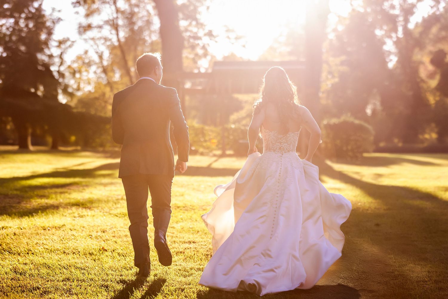 Silhouetted figures walking in a park during golden hour sunset.
