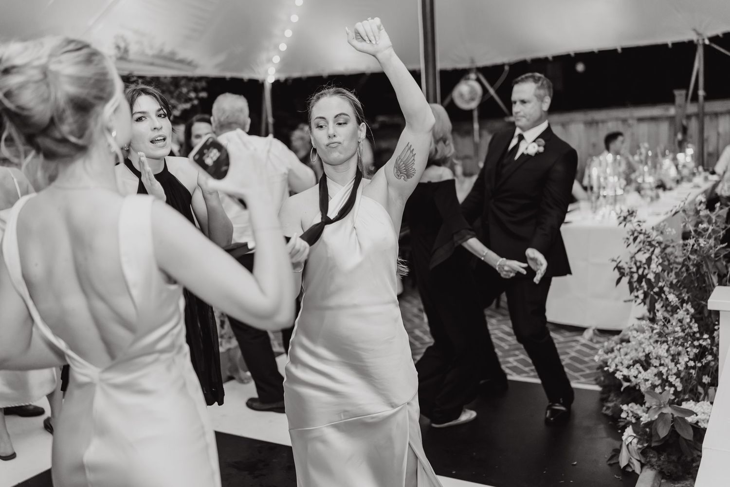 Wedding guests dancing and enjoying themselves on a lively dance floor at an evening reception.