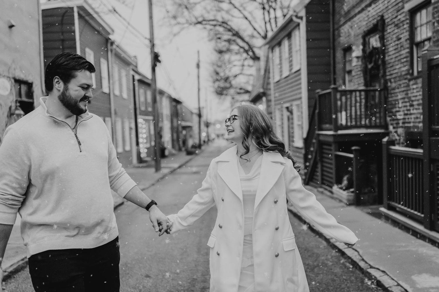 A couple dances together in a romantic black and white photo on a city street.