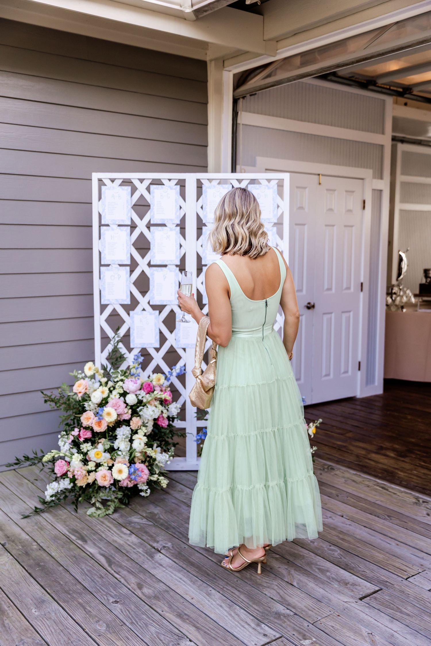 Mint green bridesmaid dresses shown against white lattice backdrop with pink floral arrangements.