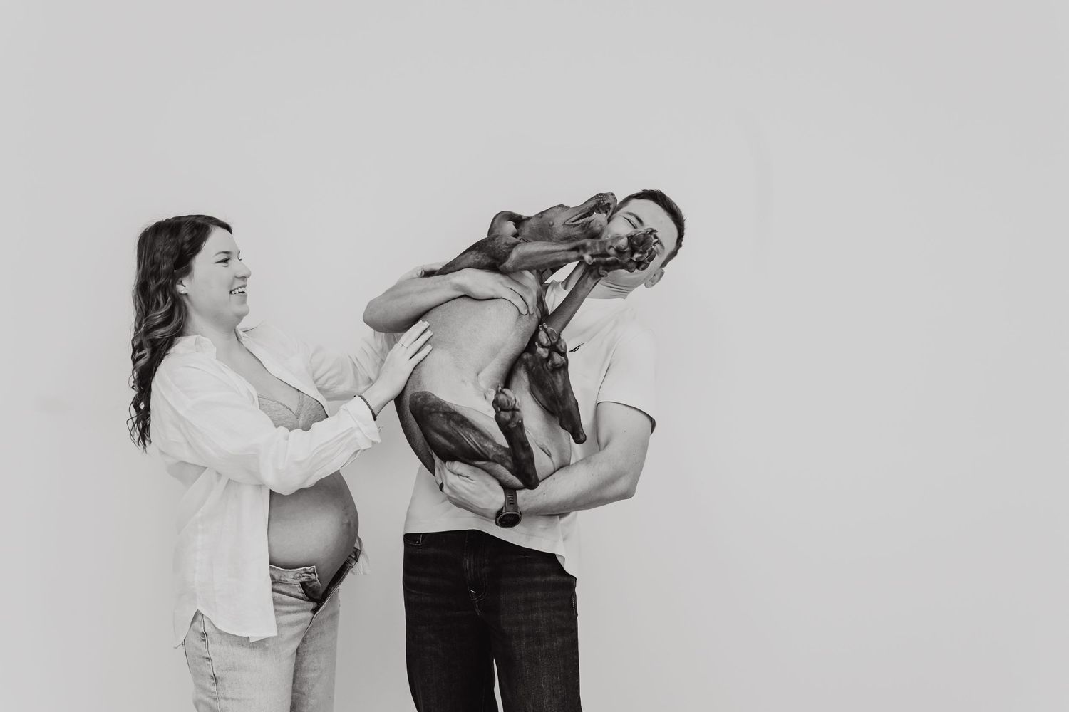 A playful black and white image of a couple posing with a record player, creating a whimsical scene.