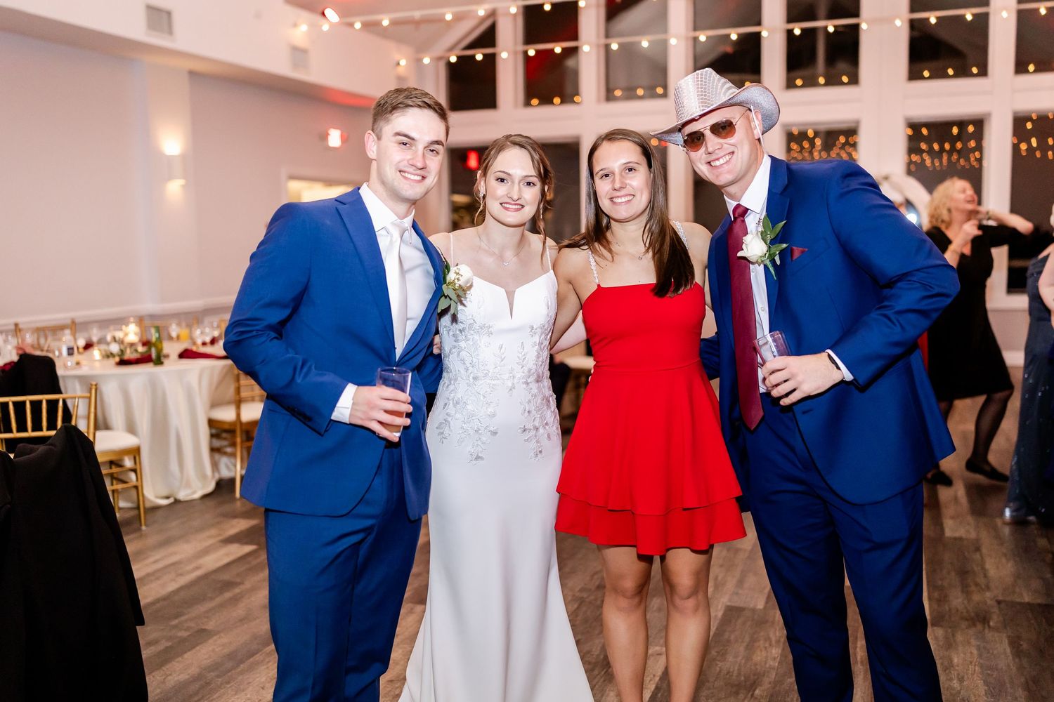 Wedding reception party with guests in formal attire dancing under string lights.
