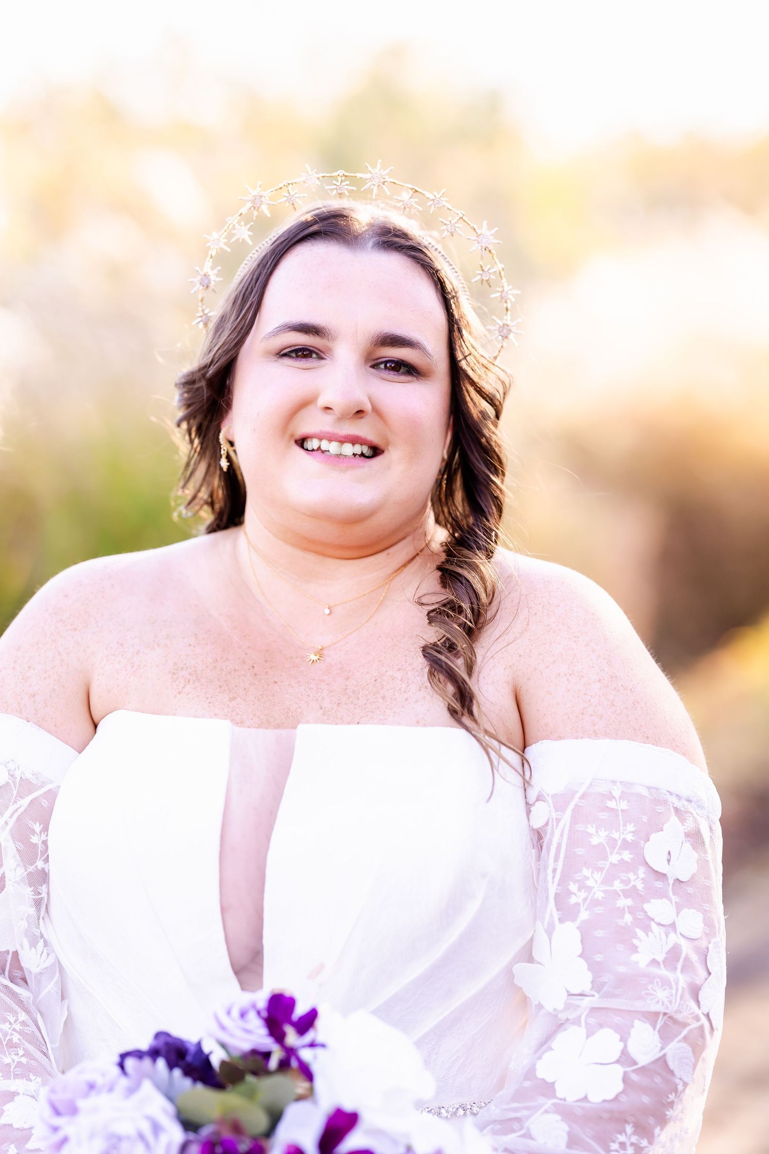 Radiant bridal portrait with delicate crown and side-braided hairstyle in natural lighting.