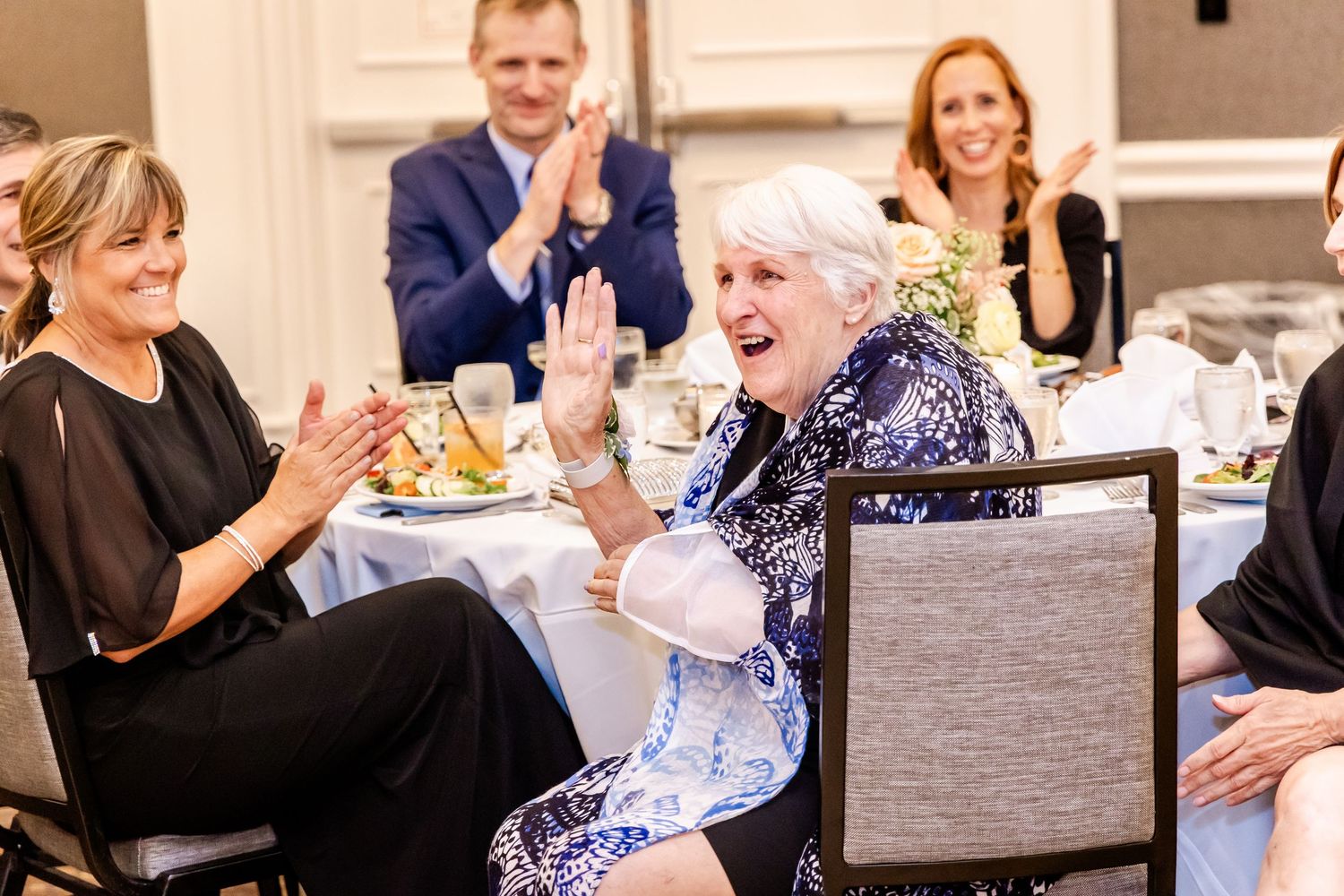 Wedding reception guests socializing and celebrating at dining tables.