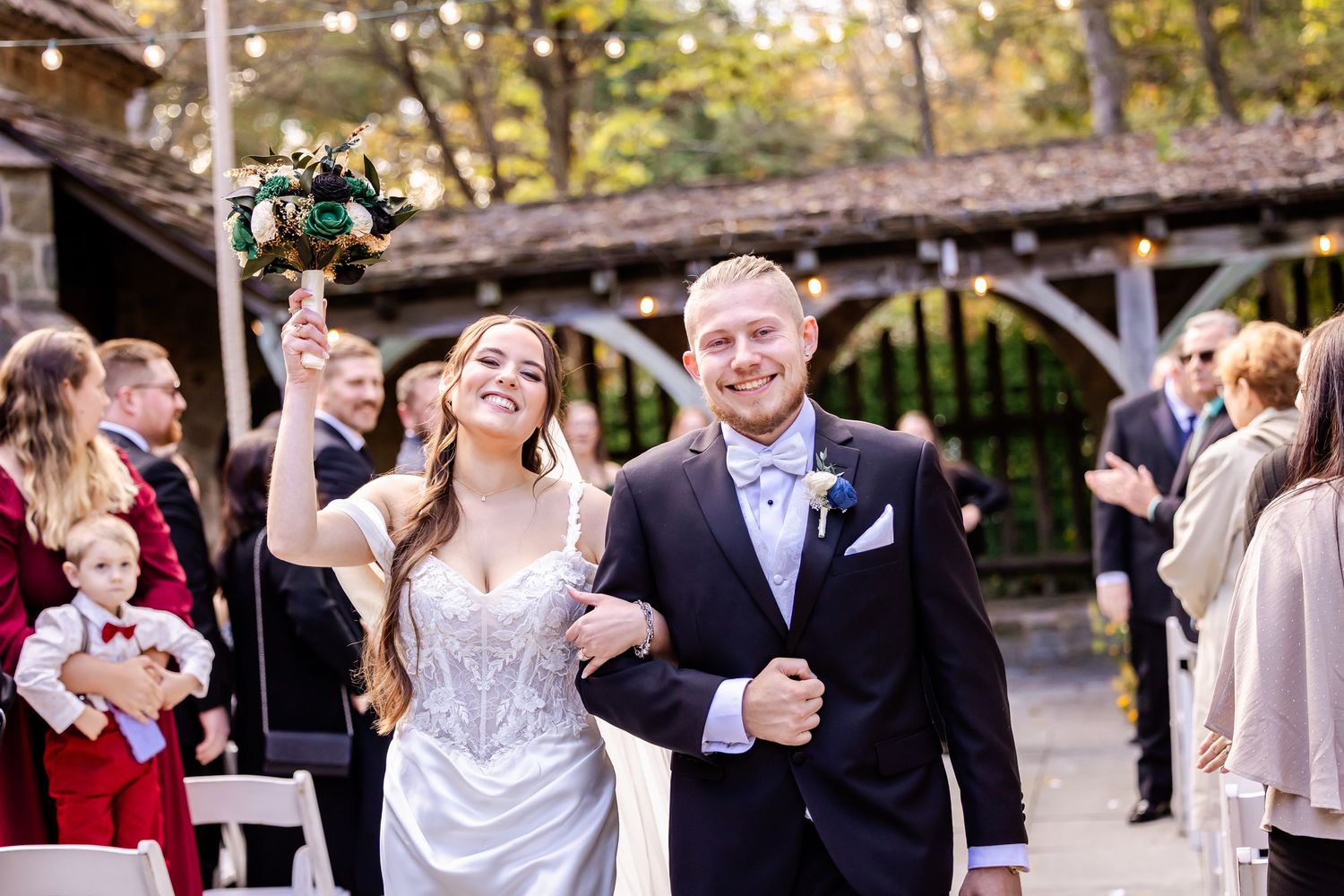 A joyful wedding celebration with guests dancing and socializing at an outdoor reception venue.